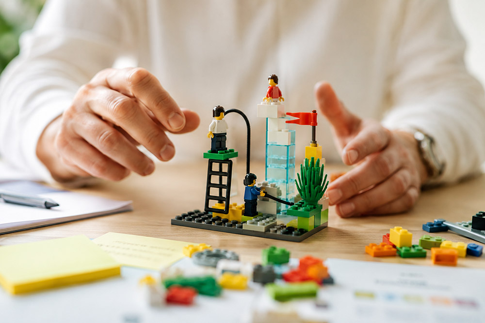 Next Level Leadership - Lego Serious Play - Asztalnál ülő férfi, aki legókockákból épít